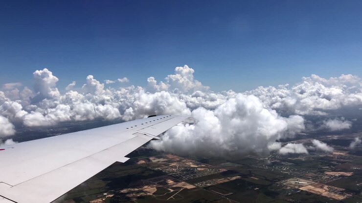 Flyvende flyvinge over hvide skyer i blå himmel