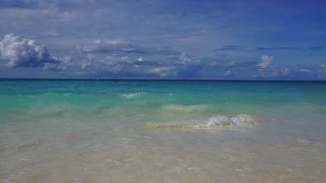 Eine-Zeitlupensequenz-Eines-Tropischen-Strandes-Mit-Kleinen-Wellen,-Die-Sanft-Gegen-Das-Ufer-Schlagen