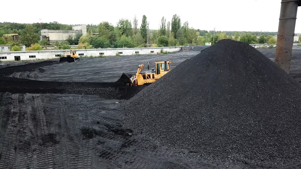 Coal mining industry. Yellow tractor loading the coal in construction site