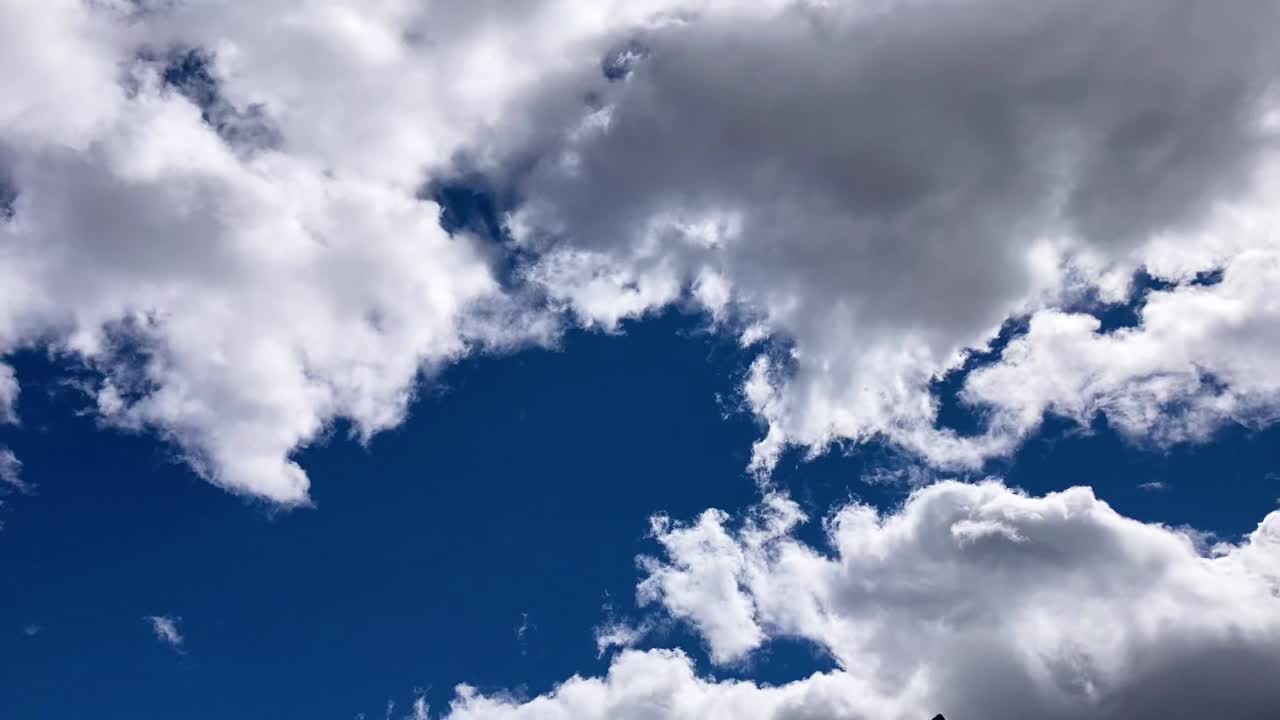 Timelapse of clouds passing across a blue sky on a sunny day
