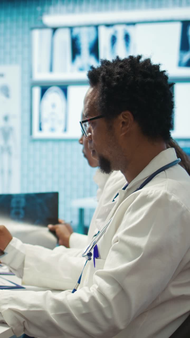 Vertical Video Physicians examining x ray scan results in a meeting with the staff
