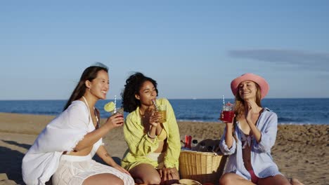 friends toasting with cocktails at the beach