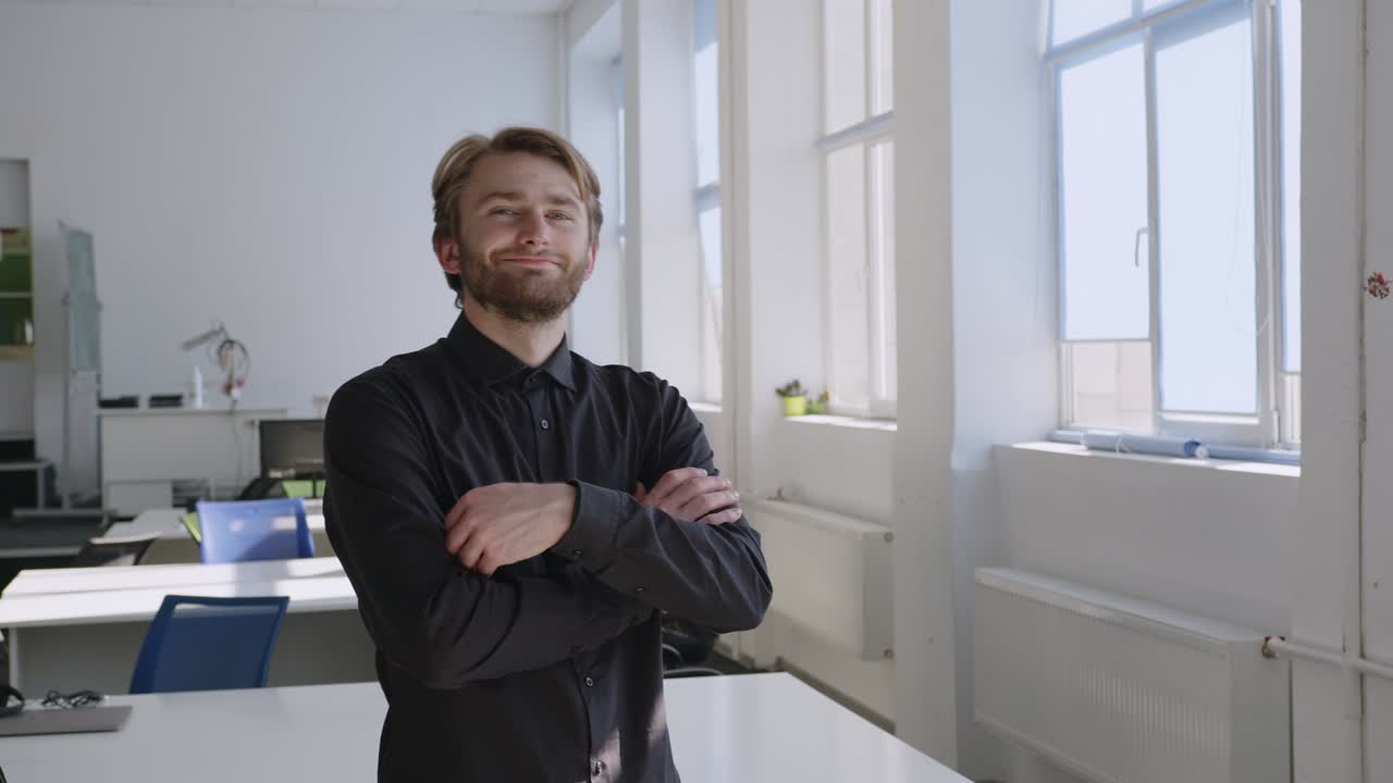 бородатый мужчина стоит и смотрит в окно