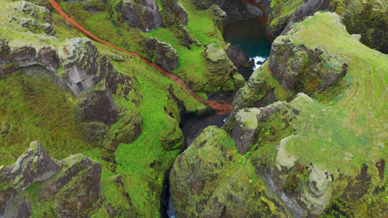 río que fluye entre el cañón cubierto de musgo de fjadrargljufur en islandia