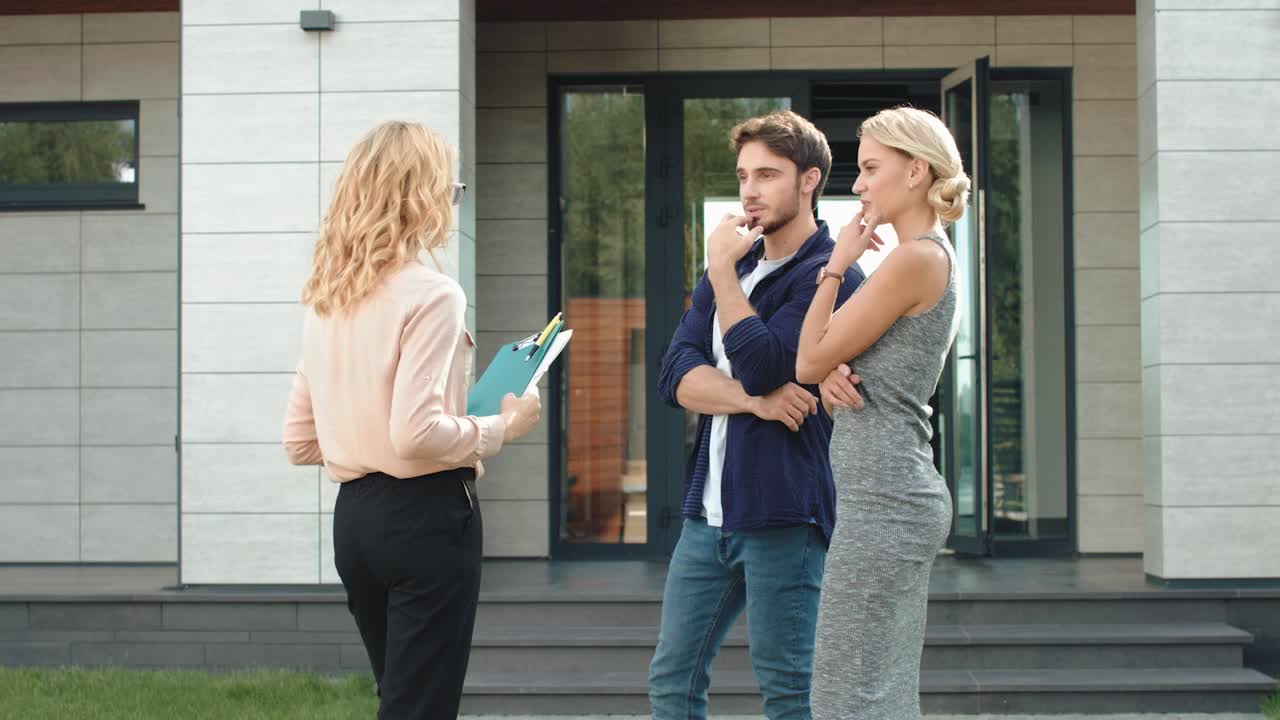 Geschäftsleute stehen in der Nähe einer Luxusvilla. Mann und Frau mieten gemeinsam ein Haus.