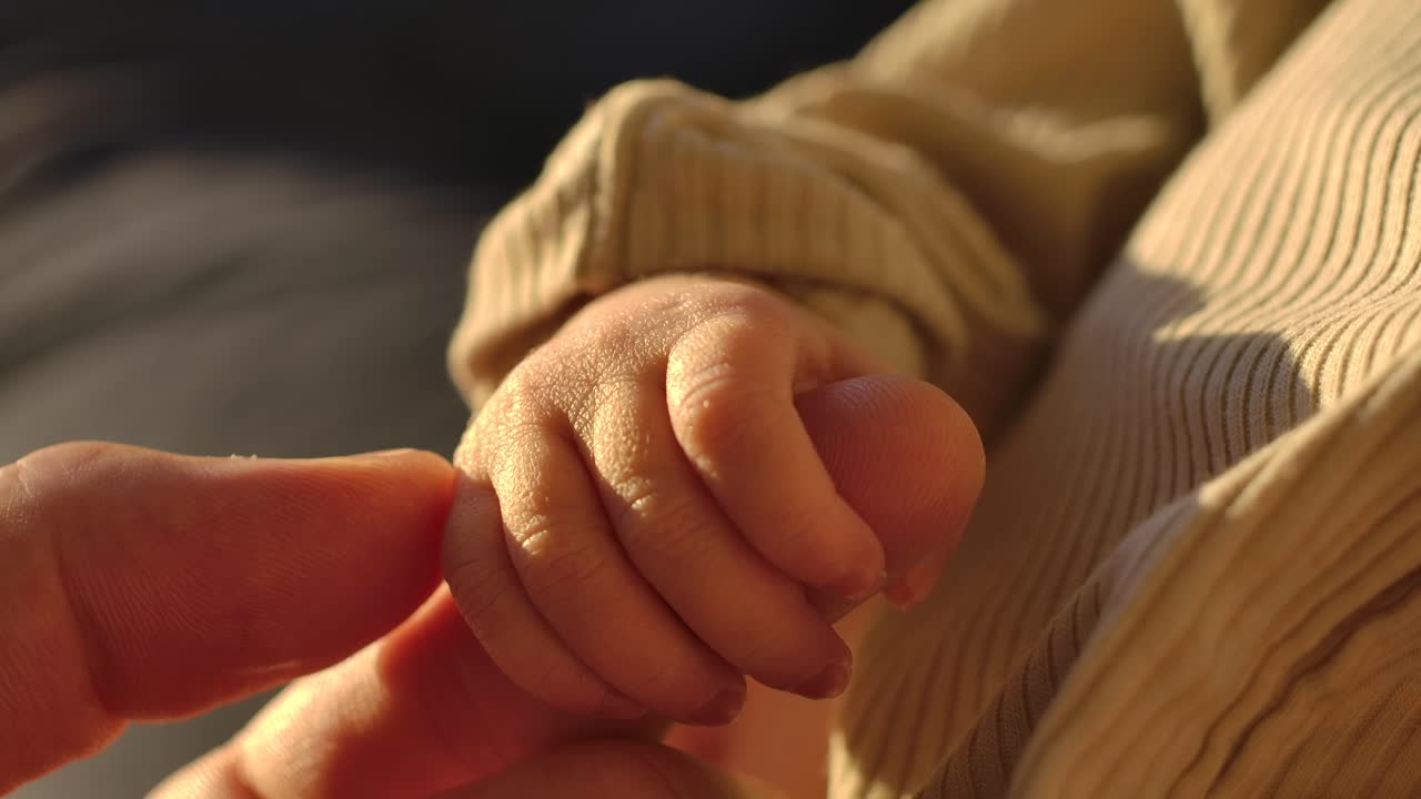 Little Baby Hand Holding Parent's Fingers - Close Up Slow Motion