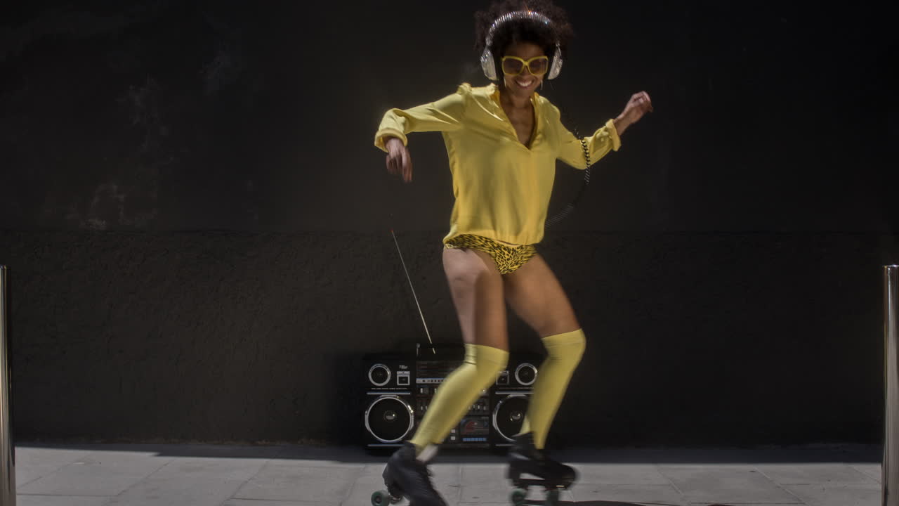 멋진 롤러 스케이팅 여성은 도시 환경에서 밖에서 춤을 추고 스케이트를 타고 있습니다.