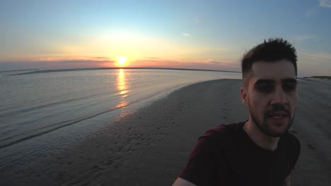 First-person-man-running-on-the-beach-with-the-sunset-behind