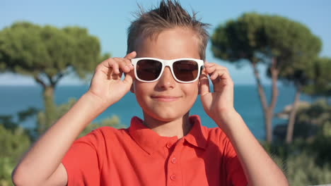 un chico sonriente disfrutando de las vacaciones de verano al aire libre. un chico relajándose en la playa.