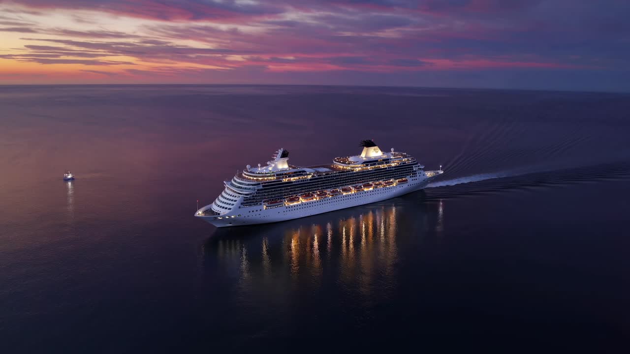 Luftfoto af et krydstogtskib ved solnedgang, der fanger rolige havrefleksioner og livlige himle