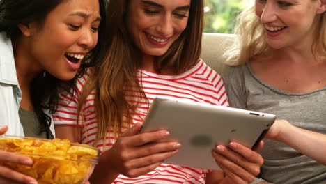 mujeres sonrientes usando una tableta