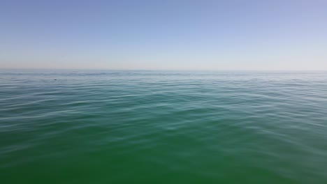 drone-shot-flying-over-a-glassy-calm-day-out-in-the-big-open-ocean-with-nothing-in-sight