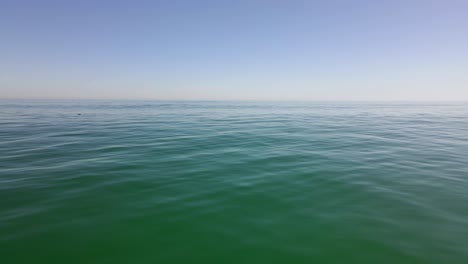 drone shot flying over a glassy calm day out in the big open ocean with nothing in sight