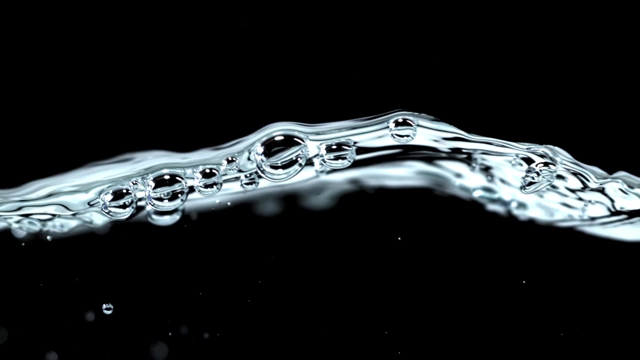 Primo piano di superficie d'acqua limpida con bolle e increspature su sfondo nero