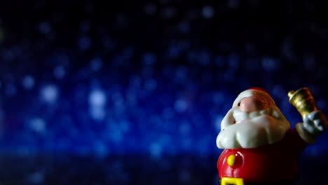 santa claus, feliz navidad y feliz año nuevo. el frente está cerca con la campana en el fondo de la nieve.
