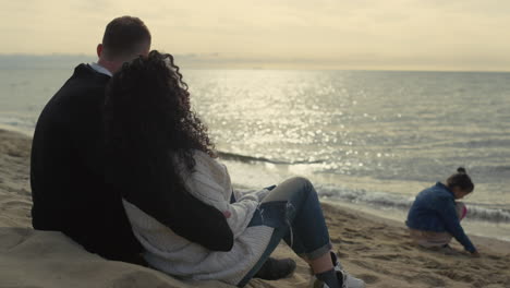 Schöne-Familie,-Die-Den-Sonnenuntergang-Am-Strand-Im-Urlaub-Am-Meer-Genießt.-Eltern-Entspannen-Sich-An-Der-Küste.