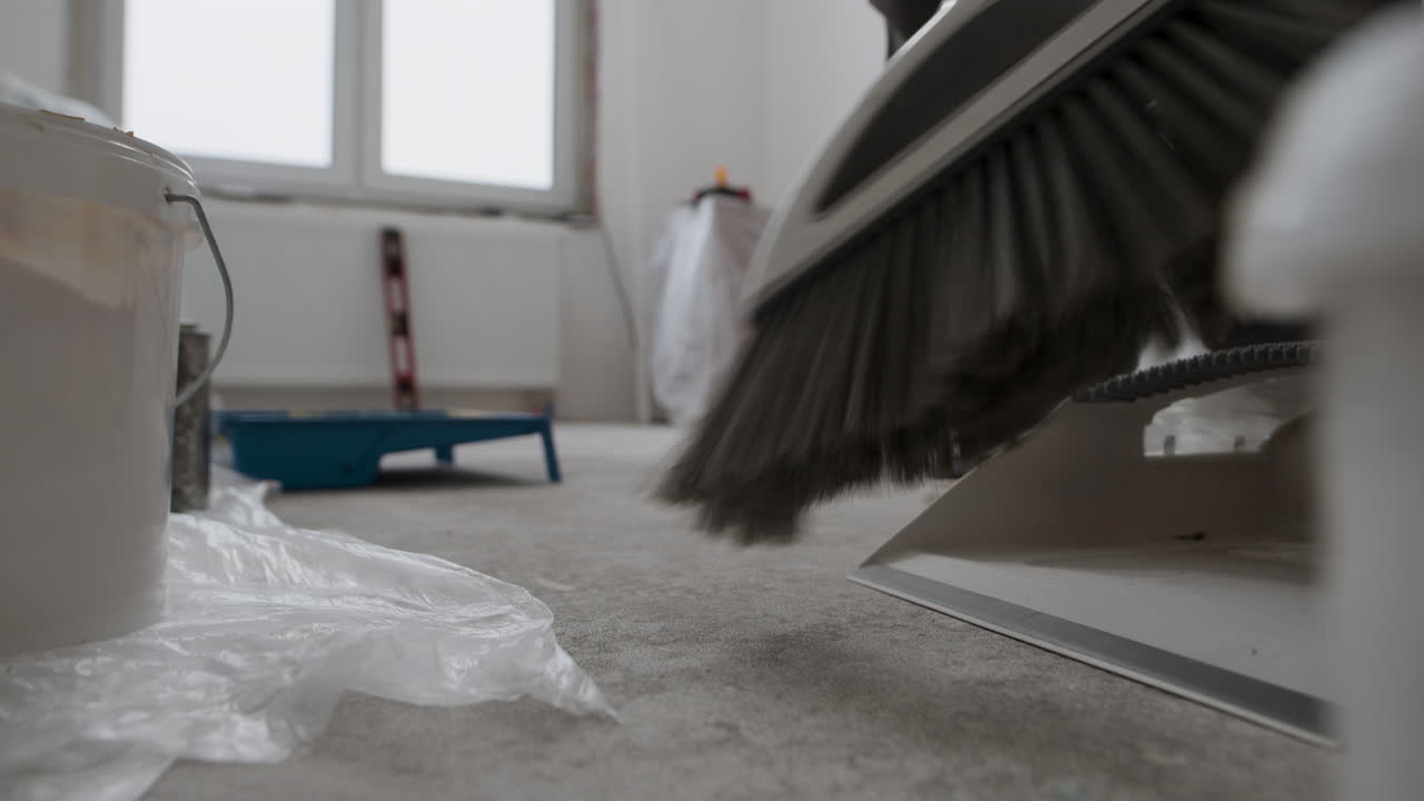 Construction Worker Sweeping the Floor After Renovation
