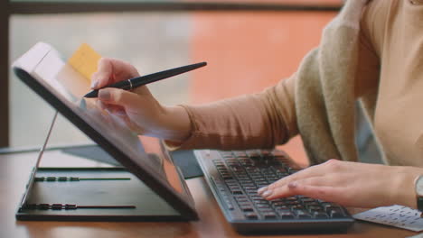 a female graphic designer works in an office with large windows and paints using a stylus and a computer touch screen. workstation with touchscreen for designers. come up with and develop the concept of the logo.