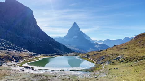 Mountain-Freedom:-Matterhorn-Mountain-Landscape-Near-Rotenboden-and-Gornergart,-Switzerland,-Europe-|-Shaky-Movement-Down-Trail-Overlooking-Scenic-Lake,-Hiking