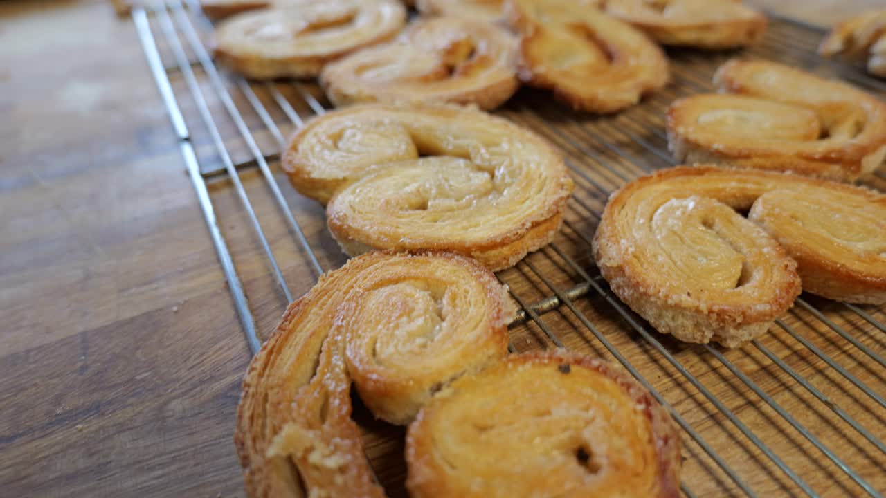 Close-up de palmiers recém-assados esfriando em uma grade de metal.