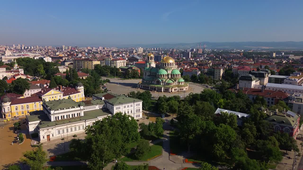 An areal cityscape of Sofia, Bulgaria with a focus on the majestic Saint Alexander Nevsky Cathedral. Drone shot of the center of Bulgaria's capital featuring the Cathedral and the old parliament.