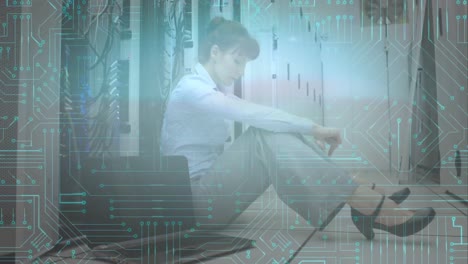 Worried-woman-sitting-in-computer-server-room-while-glowing-motherboard-moves-in-foreground