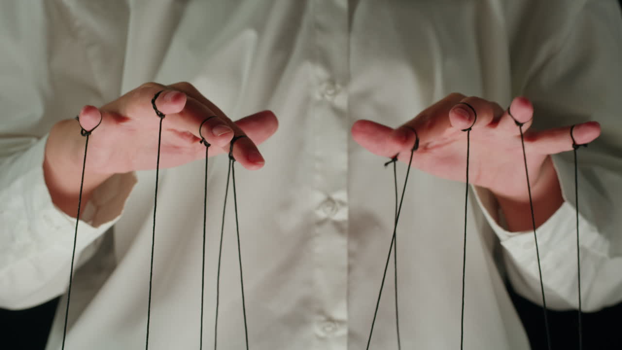 Close-Up of Puppet Master's Hands Manipulating Strings