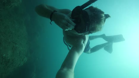 selfie pov: a young male freediver diving deep and equalizing his ears.