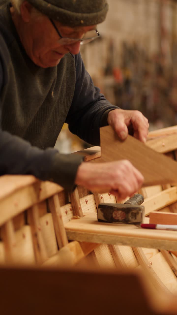 Boat builder testing fit of oak knee in wooden boat
