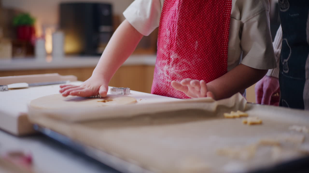 Boy Helps Dad Cut Out Cookies And Prepares To Bake Them In The Oven