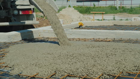 making the floor in a private cottage from the machine mixer pours concrete on the prepared base wit