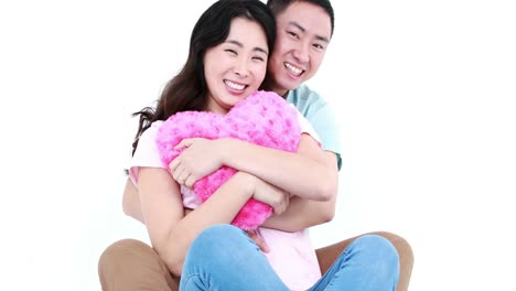 happy couple hugging and playing with a pillow