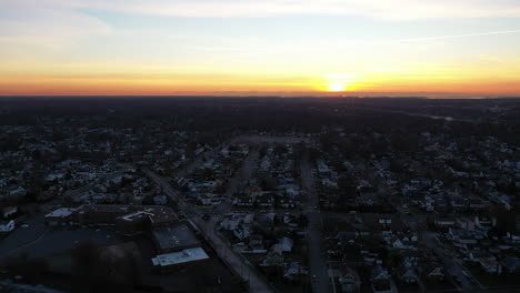 An-aerial-shot-over-a-suburban-neighborhood-during-a-golden-sunrise