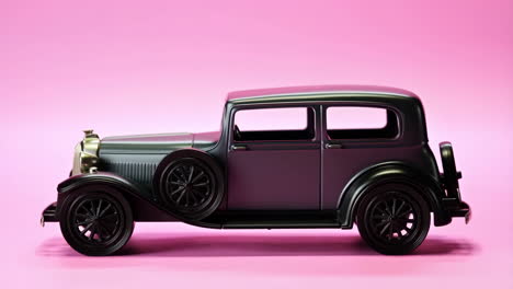 black classic toy car on pink background