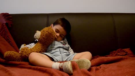 lindo niño cansado que se queda dormido en el sofá - expresiones divertidas de la cara del bebé