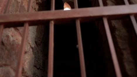 barras de hierro oxidado con un atisbo de luz en una vieja celda de prisión mogol