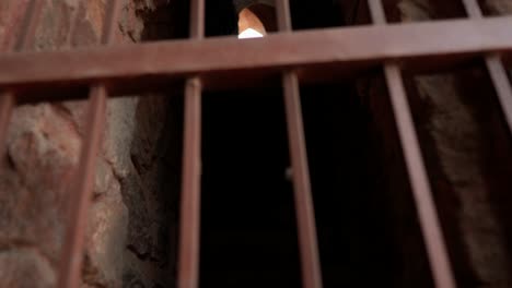 rusty iron bars with a glimpse of light in an old mughal prison cell