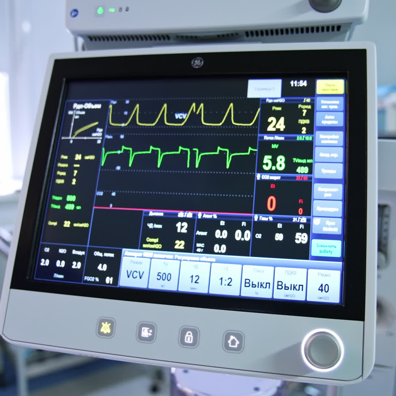 Life curves of a patient on the black screen in the surgery room. Monitor of a lung ventilator working at operation. Close up