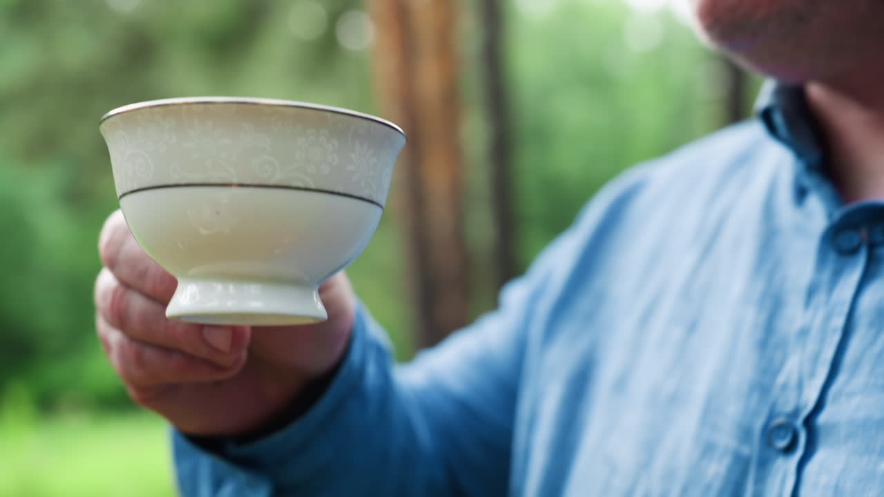 푸른 숲에서 가족끼리 피크닉을 하는 동안 어린 소녀가 아버지에게 컵을 건네는 모습이에요. 따뜻한 자연 햇빛이 부모와 아이 사이의 연결과 부드러움을 강조하며 평온한 야외에서의 순간을 함께하고 있어요.