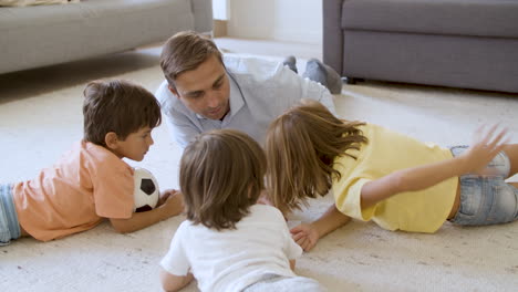 dad and sibling kids lying on warm floor