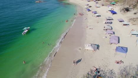 Popular-Tourist-Destination-Beach-Playa-Conchal-Beach-Costa-Rica-With-Beach-Tents-On-Summer-Day,-4K-Aerial-Drone