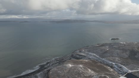 Anciano-De-Storr-En-La-Isla-De-Skye,-Escocia,-Con-Cielos-Nublados-Y-Aguas-Costeras,-Vista-Aérea