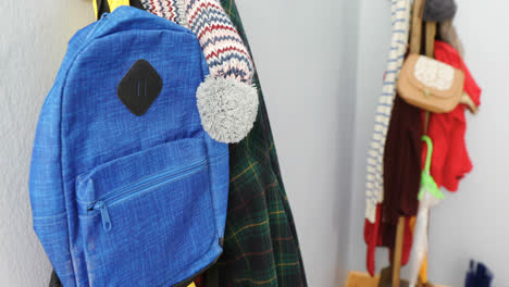 ropa de abrigo y bolsa colgando en el gancho 4k