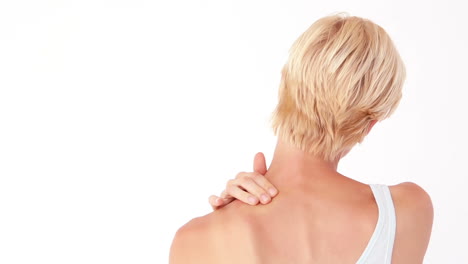 una mujer rubia masajeando su cuello.