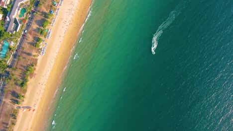 vista aérea de la playa y el océano con personas y jet ski