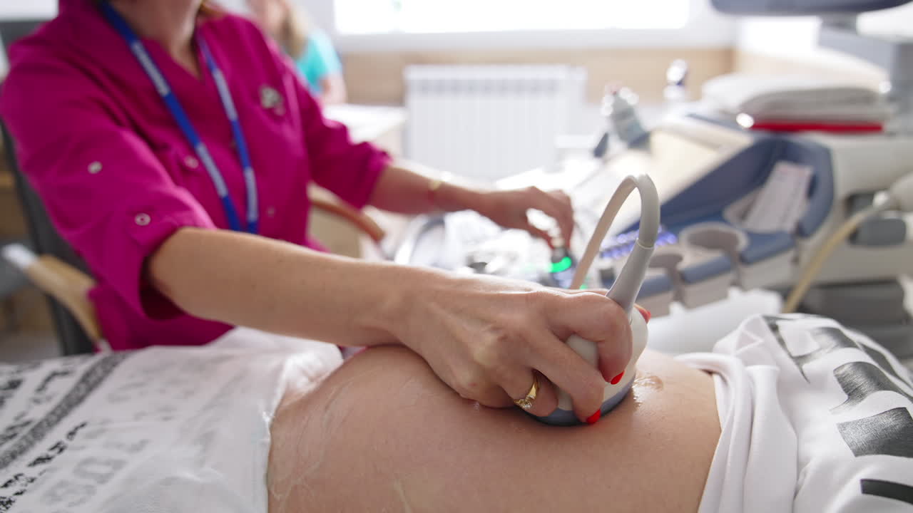 Obstetric ultrasound scans. Ultrasound investigation of a pregnant woman. Doctor doing sonography procedure on female's belly in clinic. Healthcare concept.
