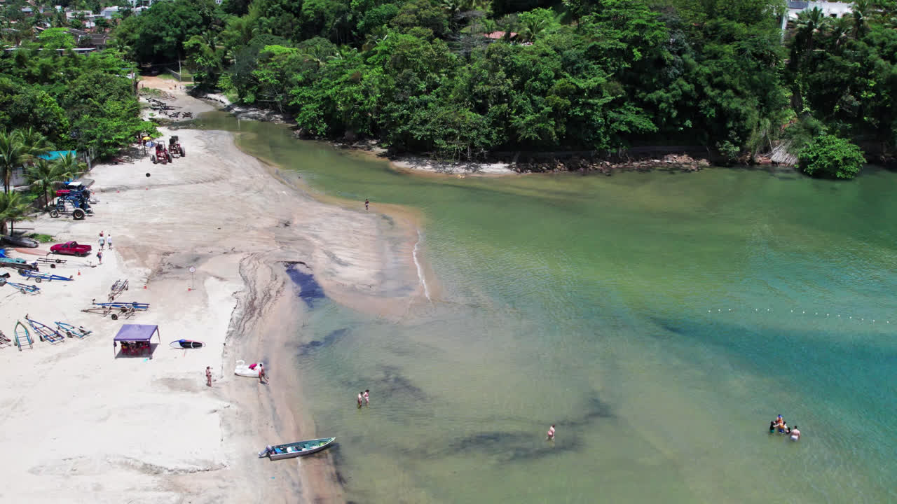 turistas relajándose en la playa de pereque mirim en un día soleado, ubatuba, brasil