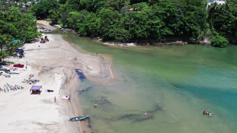 Tourists-relaxing-at-Pereque-mirim-beach-in-sunny-day,-Ubatuba,-Brazil