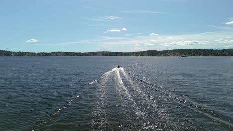 aerial shot following a speed boat on the ocean on a summer day.