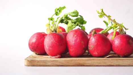 fresh red radishes on wooden board